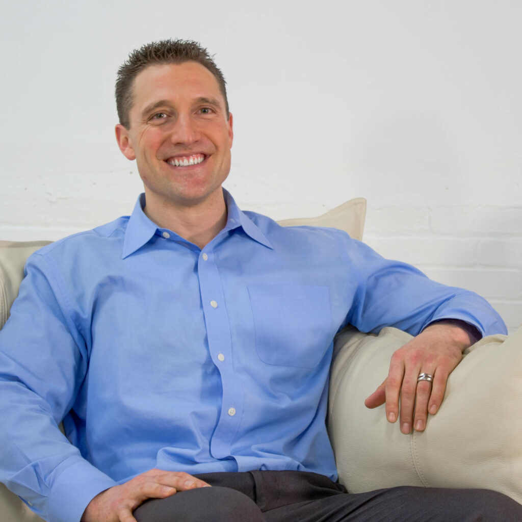 portrait photo of Dr. Todd woods, reclined on a white leather sofa